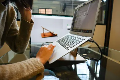 Designer with a laptop on a stand working remotely from home